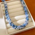 Gros plan détaillé d'un collier de perles de verre tressé bleu pour un look d'été frais - Bleu-Gris