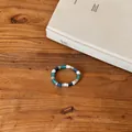 Detail view of a Korean ins style beaded bracelet with blue and white beads on wood. - Ring / Blue-White-Gray