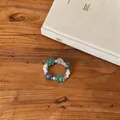 Close-up of a Korean style flower beaded ring with blue and green acrylic petals. - Ring / Blue-White-Gray