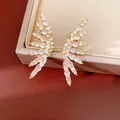 Close-up detail of 18k gold plated wing clip-on earrings with cubic zirconia stones - Gold