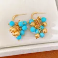 Close-up of 18k gold plated earrings with turquoise resin beads and textured gold clusters - S925 Silver Needle Style / Gold & Blue