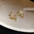 Macro view of sparkling gold-plated star earrings with cascading zircon stones for women - Meteor Style (HE33720) / Gold
