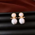 Primo piano di orecchini a perno con perle placcate in oro 18 carati e texture spazzolata - Argento
