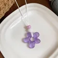 Détail d'un pendentif fleur en résine violette pour les tenues de vacances d'été - Violet