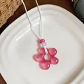 Gros plan détaillé d'un pendentif fleur en résine rose sur un collier en cuir blanc élégant - Rose
