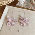 Detailed view of elegant pink flower petal earrings with sparkling cubic zirconia and pearls. - Earring Hooks / Pink