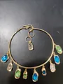 Goldene Halskette mit bunten tropfen- und ovalförmigen Edelsteinen und OT-Verschluss. - Halsband-Blau-Grün-Grau