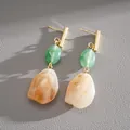 Detailed view of vintage resin drop earrings with green and amber beads and gold posts - Green-White