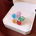 Macro view of a colorful flower ring with zirconia petals in a white jewelry box. - Colorful Zircon Flower / Silver