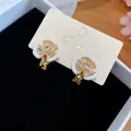 Nahaufnahme von 18 Karat vergoldeten Emaille-Blumen-Ohrclips mit Zirkonia-Steinen. - Weiße Blumenohrclips / Paar / Gold