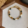 Detail view of a bohemian beaded bracelet with earthy stone beads and gold-tone spacers - Multicolor