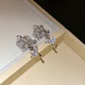 Macro detail of elegant 14k gold plated zircon flower clip-on earrings in gift box. - Clip-On Earrings / Silver