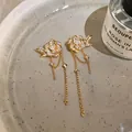 Detaillierte Ansicht der 18K vergoldeten Blumenohrringe mit Zirkonia und Quasten. - Blumen-Quasten-Stil / Gold
