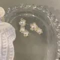 Close-up of vintage French style asymmetric pearl earrings on a clear glass tray - Asymmetric Style (HE31773-1) / Silver