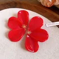 Close-up detail of red resin flower earrings featuring intricate golden stamen center - Red