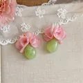 Detailaufnahme von eleganten rosa Chiffonblumen und grünen Harztropfen Ohrringen für Damen - Resort Floral Stil / Rosa und Grün