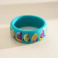 Macro view of a teal resin bangle decorated with colorful tropical fish illustrations - Tropical Fish Print / Blue