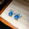 Close-up of vintage style silver zircon and pearl stud earrings with blue geometric stones - Silver Earring Post Style / Blue