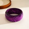 Exquisite close-up detail of a purple resin bangle with star and snowflake glitters - Purple