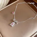 Detailed shot of a silver bear pendant necklace with sparkling pink zircon hearts. - Silver-Pink