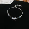 Close-up detail of an elegant silver bowknot bracelet decorated with light blue stones - Bracelet-Silver-Blue