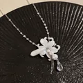 Detailed view of white lily flower necklace with pearls and clear teardrop charm - Silver-White