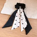 Detail view of a French style black scrunchie with a polka dot bow ribbon tail. - Black and White (With Long Ribbon)