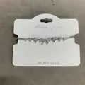 Exquisite silver-tone bracelet with zircon bow and heart charms on a white display card. - Silver-Clear