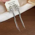 Detailed view of elegant firework tassel earrings with pearls and crystals. - Silver