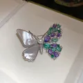 Close-up of asymmetrical butterfly brooch with mother-of-pearl and colorful zircons. - Purple Blue