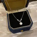 Close-up detail of silver necklace with CZ flower and white pearl pendant in box - White Pearl / Silver