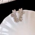 Dettaglio macro di orecchini a coniglio in argento con fiori di zircone scintillanti - Orecchini Pendenti / Perno in argento 925 / Argento