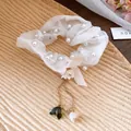 Dettaglio di elegante elastico per capelli in tulle bianco con perle e nappe a foglia - Bianco