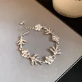 Dettaglio di bracciale argento con fiori e rami irregolari, finitura metallica testurizzata - Bracciale / Argento