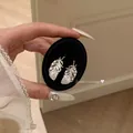 Close-up of elegant silver feather stud earrings with sparkling diamonds - Feather Stud Earrings / Silver