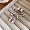 Close-up view of elegant silver-tone hollow geometric earrings in a jewelry tray - Silver Needle / Silver