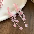 Close-up of pink beaded tassel earrings with delicate shell flower charms - Silver Post Shell Flower Tassel Style / Pink