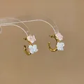 Detailed macro view of Korean C-shaped heart earrings with pink and white glass accents - Heart C-Shaped Style / Gold + Pink