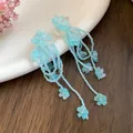 Close-up of light blue beaded tassel earrings with delicate flower accents - Silver Post Shell Flower Tassel Style / Blue