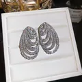 Detail shot of multi-layer spiral earrings with shimmering cubic zirconia in a white gift box. - Stud Earrings / Clear