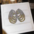 Detail view of multi-layered silver earrings with yellow and white zircons - Stud Earrings / Yellow