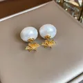 Close-up of vintage pearl earrings with gold flower base and textured white pearls - Gold-White