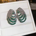 Macro view showing the intricate layered teardrop design of green and white zircon earrings. - Stud Earrings / Green