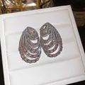Macro view of luxury multi-layer spiral earrings featuring pink and white zircon stones - Stud Earrings / Pink