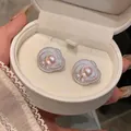Detail view of elegant silver flower stud earrings with pink pearls in a gift box - Round Flower Style / Silver Pink