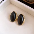 Primer plano de los pendientes de resina negra de estilo francés vintage con borde dorado - Negro