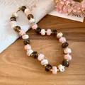 Close-up of handmade chunky necklace featuring multi-colored marble-textured beads - Geometric Beaded Style / Pink-Khaki-Coffee