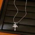 Silver double cross necklace with zircon star pendant displayed on a black jewelry tray. - Silver