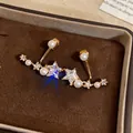 Macro shot of gold-plated star earrings with cubic zirconia and pearls in a brown box - Gold