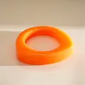 Detailaufnahme eines leuchtend orange marmorierten Harzarmbands in unregelmäßiger Form. - Orange